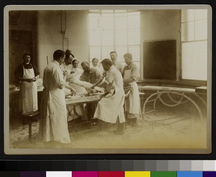 Equipe médicale posant un plâtre sur la jambe d'un patient, salle d'opération de l'Hôpital cantonal.