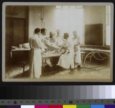 Equipe médicale posant un plâtre sur la jambe d'un patient, salle d'opération de l'Hôpital cantonal.