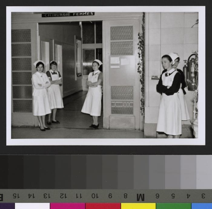 Groupe d'infirmières posant devant la porte d'entrée de la Chirurgie des femmes.
