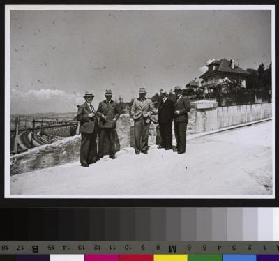 Goupe de cinq hommes devant le domaine de Chatagny (rattaché à l'Hôpital cantonal). A gauche de l'image, les voies du chemin de fer; au fond, à droite, des maisons.