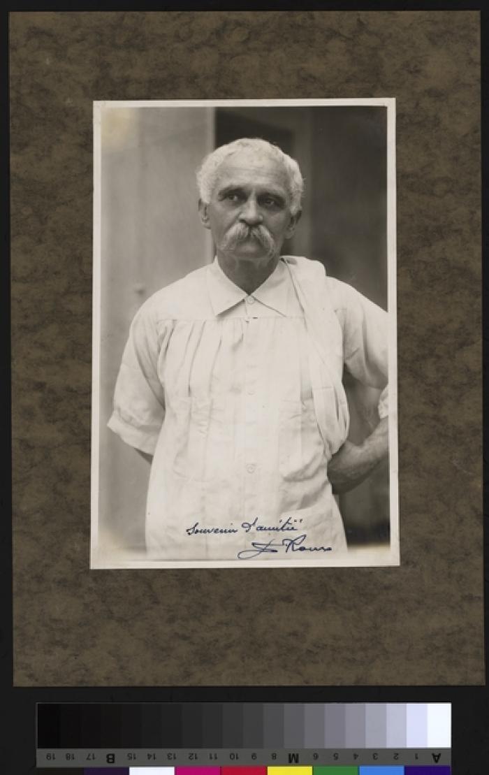 Portrait du Prof. Dr. César Roux, debout, mi-corps, cheveux blancs et moustache grise. Il porte une blouse de médecin et un linge sur l'épaule gauche.