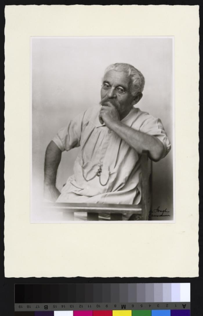 Portrait du Prof. Dr. César Roux, mi-corps, cheveux blancs et moustache grise, de petites lunettes rondes à armatures de fer sur le nez ; une chaîne est attachée à sa blouse de médecin.